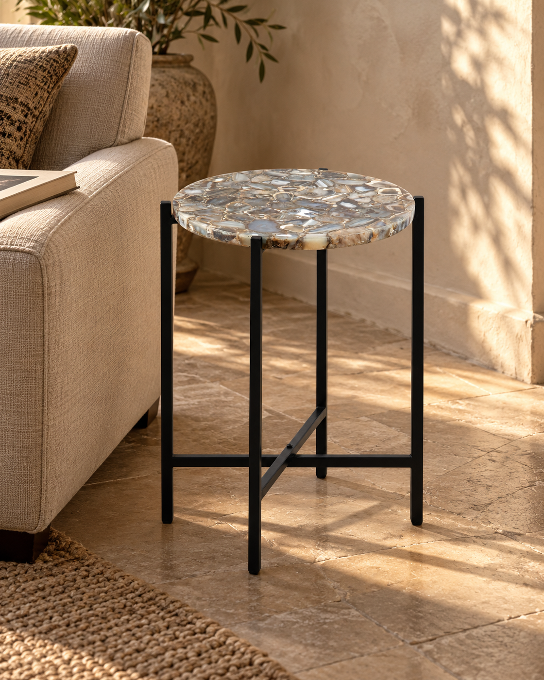 Orlina agate accent table beside a linen chair in warm directional sunlight.