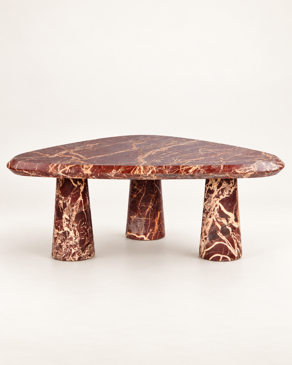 Rosso coffee table with a rounded triangular top and three tapered legs