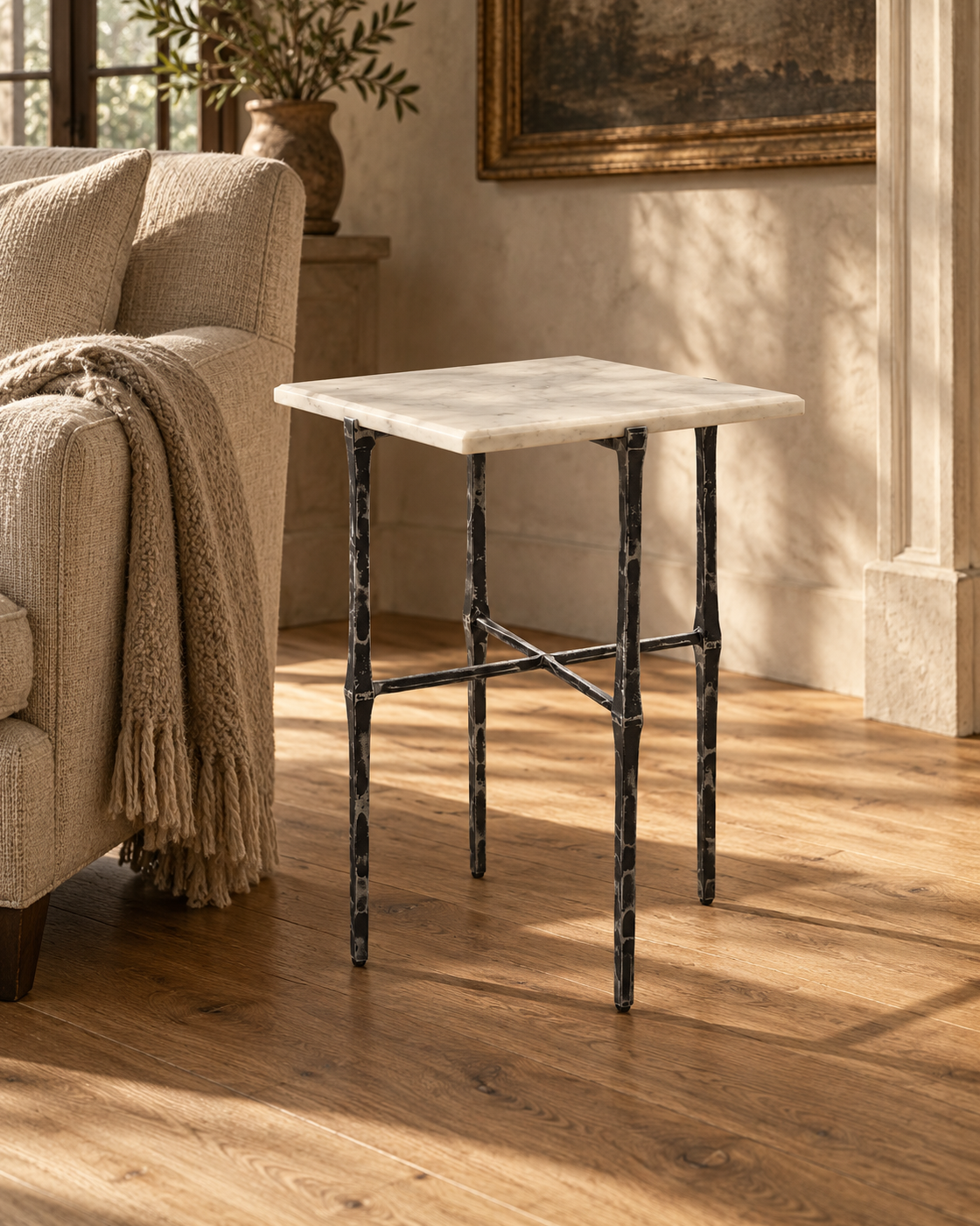 Avelis Marble Accent Table beside a linen armchair in a sunlit sitting room.