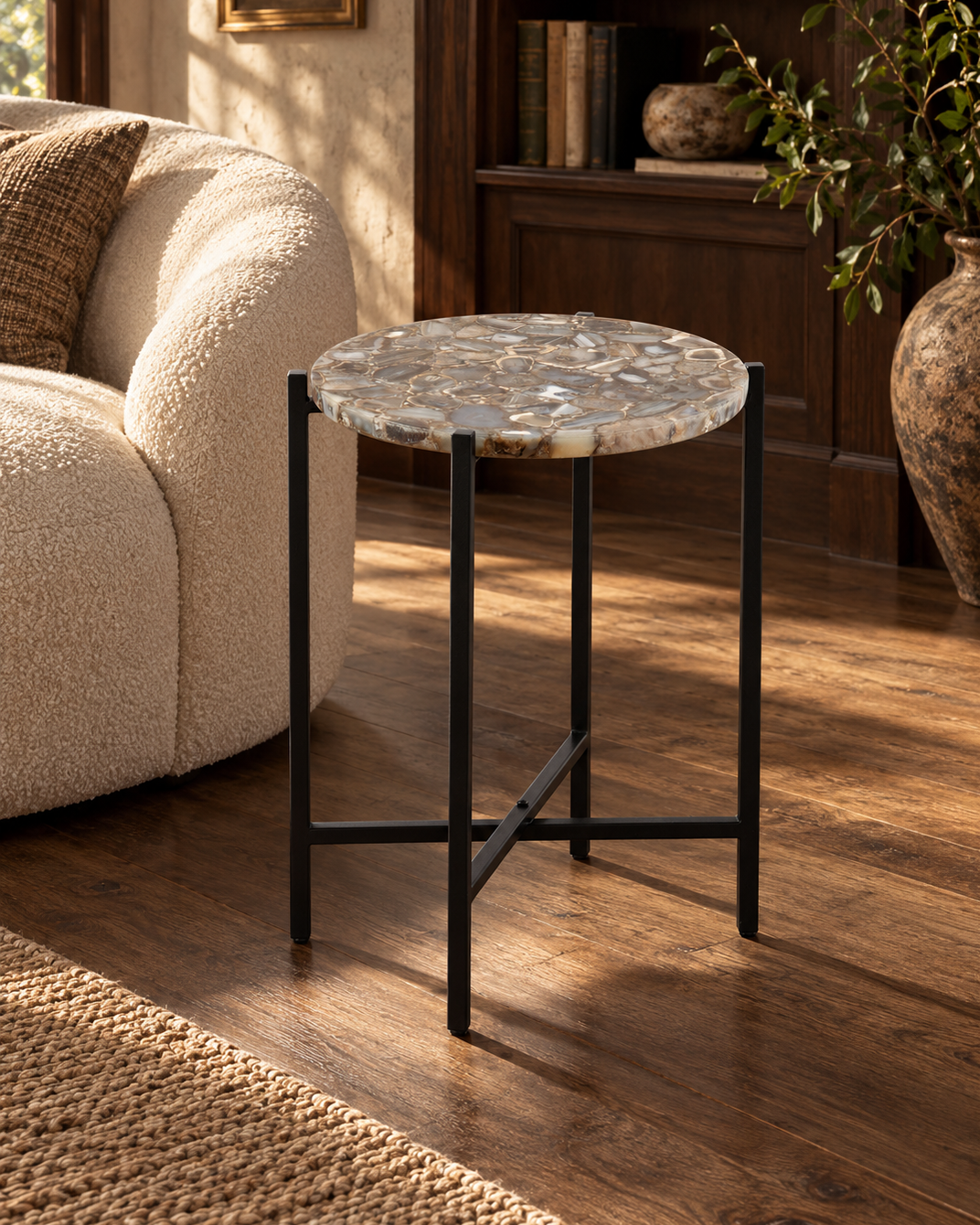 Orlina agate accent table beside a cream sofa and wood library shelves.